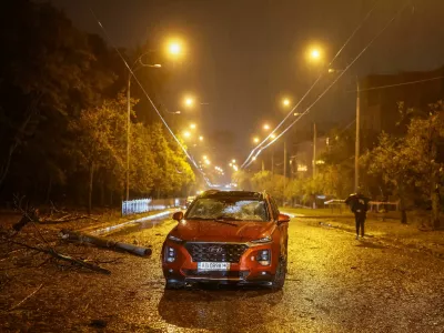 A resident walks near a destroyed car at the site of a Russian missile strike near a maternity hospital, amid Russia's attack on Ukraine in Kyiv, Ukraine September 24, 2026. REUTERS/Gleb Garanich