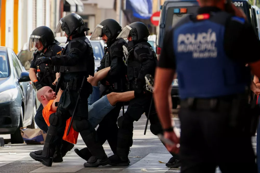 Spanish riot police removes one of the activits, who were trying to prevent the eviction of Maricarmen Abascal, 87, who was evicted from the Madrid home where she had lived for more than seven decades after the apartment was acquired by an investment fund that sought a steep increase in her rent, despite efforts by housing activists to broker an alternative arrangement in Madrid, Spain, September 23, 2026. REUTERS/Susana Vera