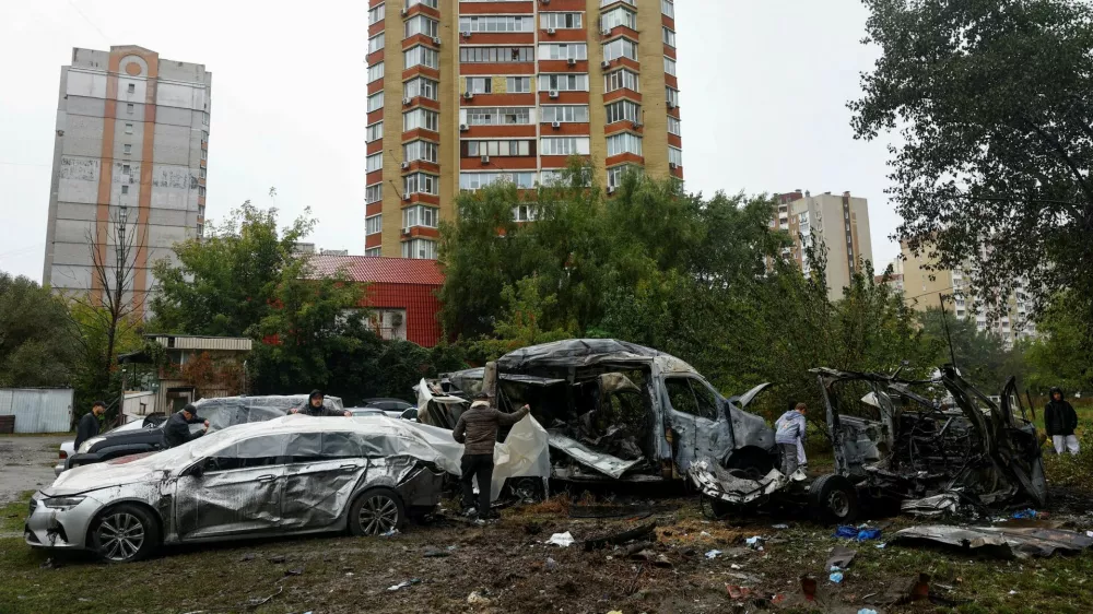 Residents use plastic film to cover their damaged cars hit by a Russian drone strike at a parking lot in a residential area, amid Russia's attack on Ukraine, in Kyiv, Ukraine September 24, 2026. REUTERS/Valentyn Ogirenko