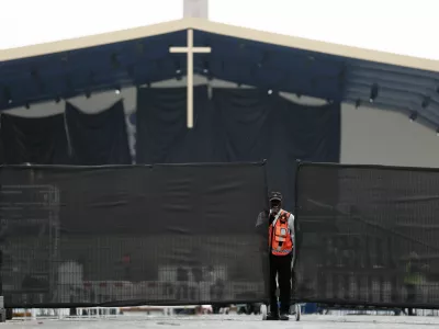 A member of security personnel stands near fences as workers set up infrastructure for an open-air Mass to be celebrated by Pope Leo at the Place de la Concorde in Paris on the eve of his four-day apostolic journey to France, September 24, 2026. REUTERS/Benoit Tessier