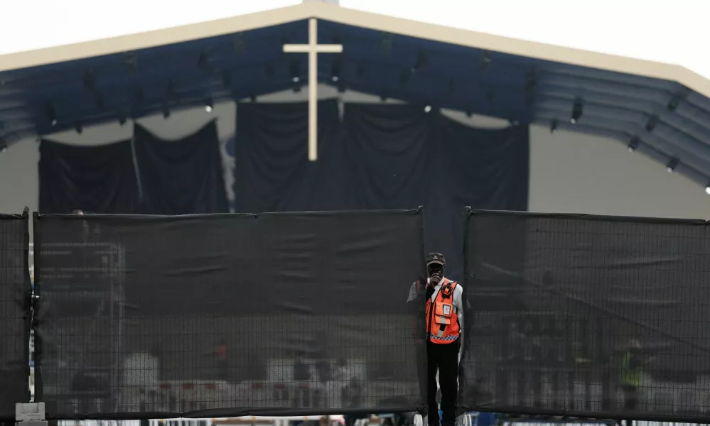 A member of security personnel stands near fences as workers set up infrastructure for an open-air Mass to be celebrated by Pope Leo at the Place de la Concorde in Paris on the eve of his four-day apostolic journey to France, September 24, 2026. REUTERS/Benoit Tessier