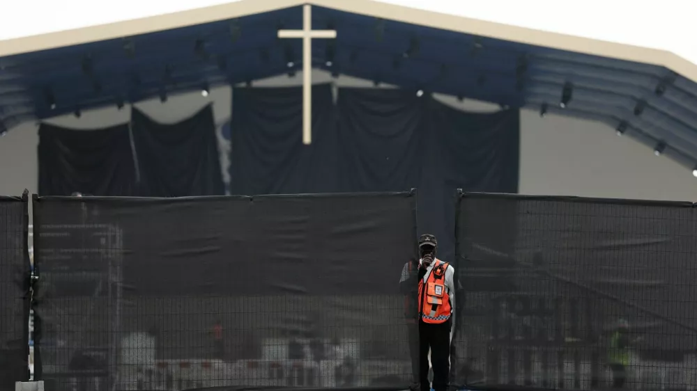 A member of security personnel stands near fences as workers set up infrastructure for an open-air Mass to be celebrated by Pope Leo at the Place de la Concorde in Paris on the eve of his four-day apostolic journey to France, September 24, 2026. REUTERS/Benoit Tessier