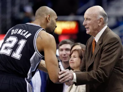 FILE - San Antonio Spurs power forward Tim Duncan (21) shakes hands with former NBA player Bob Pettit before the start of the Spurs New Orleans Hornets NBA basketball game in New Orleans, Monday, Jan. 7, 2013. (AP Photo/Bill Haber, File)