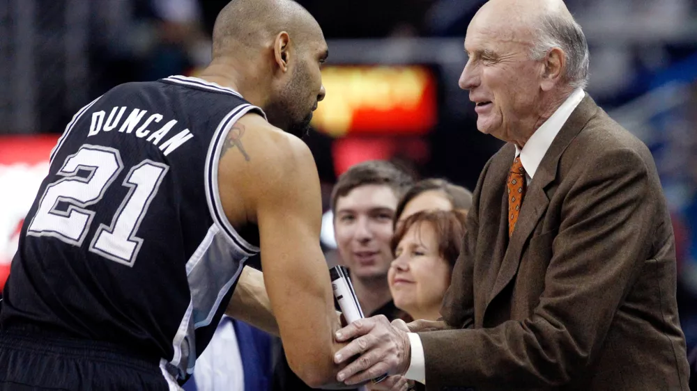 FILE - San Antonio Spurs power forward Tim Duncan (21) shakes hands with former NBA player Bob Pettit before the start of the Spurs New Orleans Hornets NBA basketball game in New Orleans, Monday, Jan. 7, 2013. (AP Photo/Bill Haber, File)