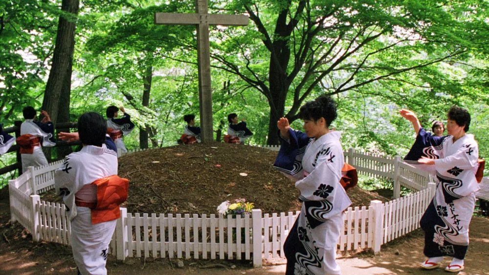 - FILE PHOTO 6JUN99 - Kimono-clad local women perform a traditional folk dance around a grave with a cross in northern Japanese town of Shingo in this file photo taken June 6. Locals believe that, contrary to what the Bible says, Jesus Christ died not on Calvary but in this remote northern Japanese town among mountains and rice fields, his previously unheard-of younger brother crucified in his place instead.