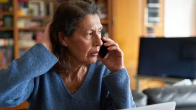 Stressed senior businesswoman on the phone while working on laptop