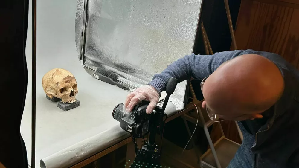 Od lobanje do obraza. Forenzični umetnik Oscar Nilsson med fotografiranjem lobanje Lady 56, na podlagi katere je izdelal rekonstrukcijo njenega videza. Foto: Anders G&ouml;therstr&ouml;m/Stockholms universitet / Foto:. Foto: Anders G&ouml;therstr&ouml;m/stockholms Universitet