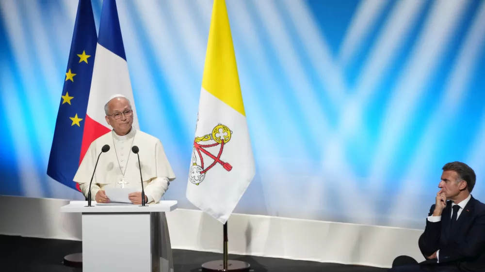 French President Emmanuel Macron, right, listens to Pope Leo XIV delivering his speech at the meeting At the Roots of Europe for Peace and Unity, Monday, Sept. 28, 2026, in Metz, France. (AP Photo/Gregorio Borgia)