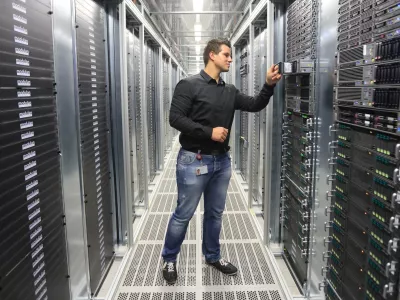 System administrator Benjamin Fischer checks a server in the new computer center of Deutsche Telekom AG in Biere, Germany, 01 July 2014. The subsidiary T-Systems will open the largest computing center in Germany on 03 July 2014 with an area of 150,000 square meters. There will be 30,000 servers here and 100 employees. Together with the center in Magdeburg, the "TwinCore" allows for applications and client data to be handled in parallel at two locations for security reasons. T-Systems wants to satisfy the high demand for cloud service by companies with the facility. Photo by: Jens Wolf/picture-alliance/dpa/AP Images