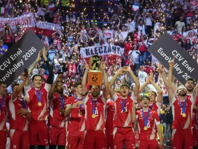 Poland's Aleksander Sliwka, center, holds the trophy as he celebrates with teammates on the podium after winning the men's European volleyball championship final match against France in Milan, Saturday, Sept. 26, 2026. (AP Photo/Antonio Calanni)