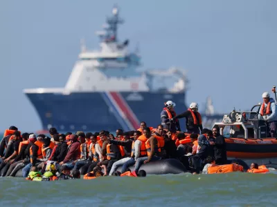 FILE - A group of migrants try to cross the channel from France to Britain on a dinghy boat, in Hardelot, northern France, Wednesday, Sept. 23, 2026. (AP Photo/Jean-Francois Badias, File)