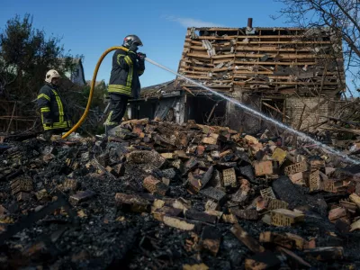 Rescue workers put out a fire at a residential house destroyed in a Russian missile strike on Vyshhorod, Kyiv region, Ukraine, Wednesday, Sept. 30, 2026. (AP Photo/Evgeniy Maloletka)