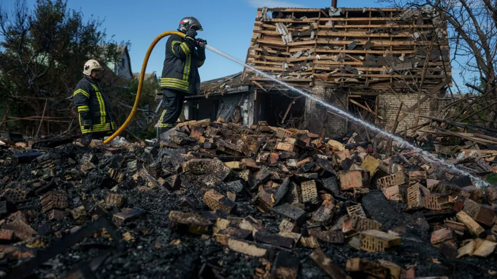 Rescue workers put out a fire at a residential house destroyed in a Russian missile strike on Vyshhorod, Kyiv region, Ukraine, Wednesday, Sept. 30, 2026. (AP Photo/Evgeniy Maloletka)