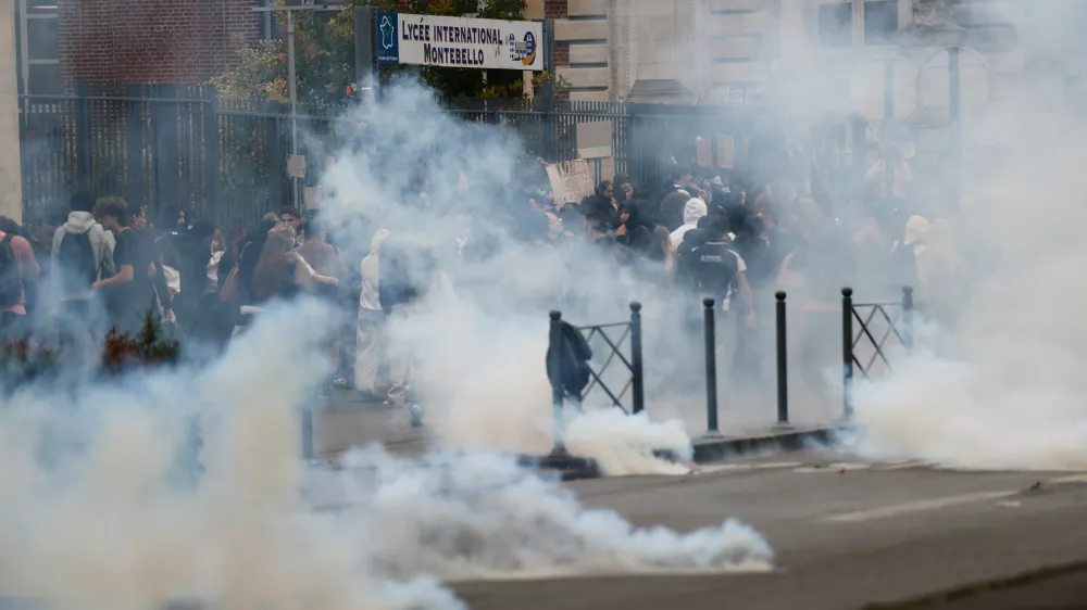 Riot police throw tear gas as high school students block the entrance of a school during a protest to demand more resources for schools, in Lille, France, Wednesday, Sept. 30, 2026. (AP Photo/Jean-Francois Badias)