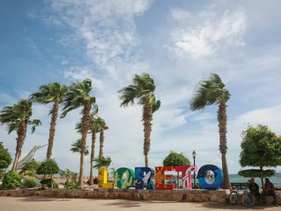 People sit near a logo in Loreto, as Hurricane Polo approaches Baja California Sur, Mexico, September 28, 2026. REUTERS/Raquel Cunha