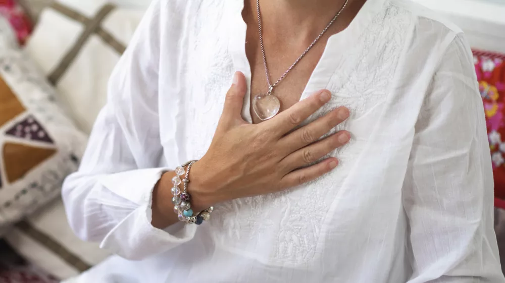 Self-Healing Heart Chakra Meditation. Woman sitting in a lotus position with right hand on heart chakra. Spiritual Awakening. / Foto: Microgen Getty Images