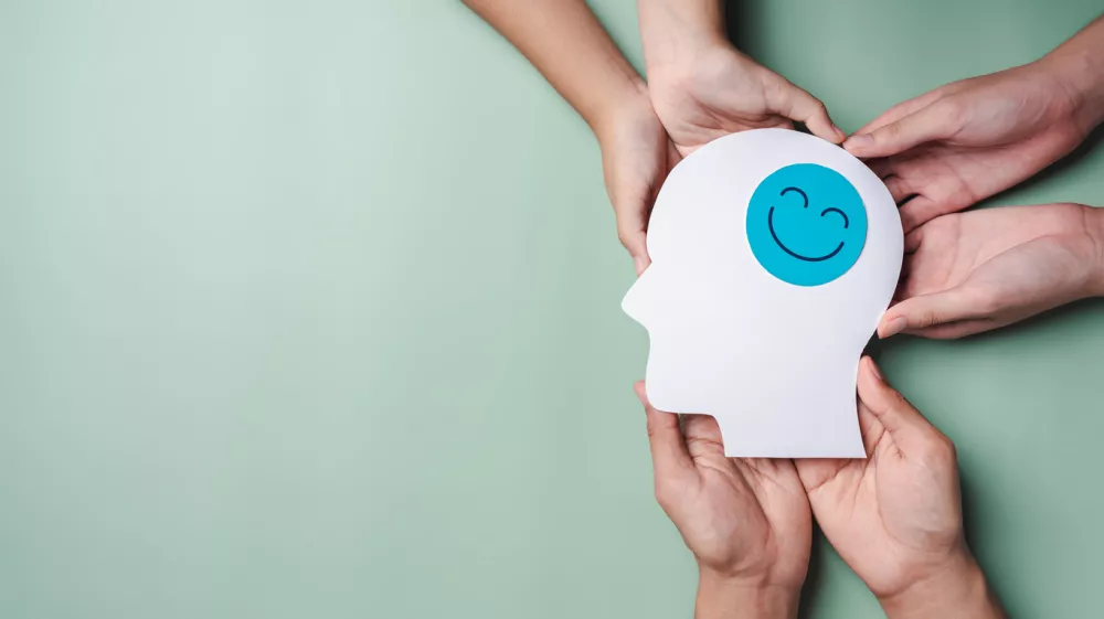 hands holding smile face in brain paper cut, happy smiley emotion and relax mood hormones, full energy feeling, brain chemicals, positive mental health concept / Foto: Champpixs Getty Images
