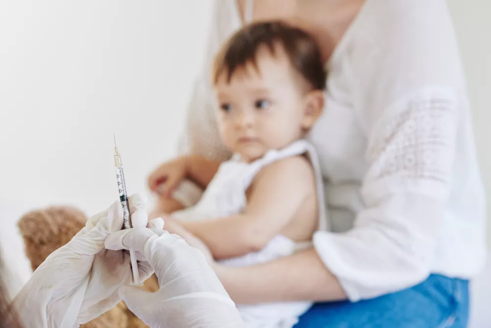 Close-up image of doctor in rubber gloves ready to vaccinate little girl for influenza or coronavirus / Foto: Dragonimages Getty Images