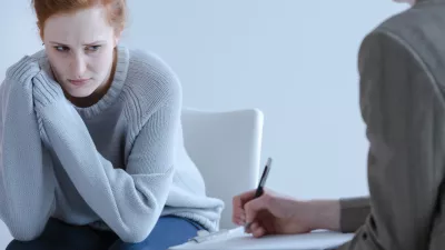 Sad young woman with eating disorders during meeting with psychotherapist