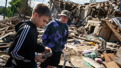 A boy looks at fragment of a rocket in front of a residential house destroyed in a Russian missile strike on Vyshhorod, Kyiv region, Ukraine, Wednesday, Sept. 30, 2026. (AP Photo/Evgeniy Maloletka)