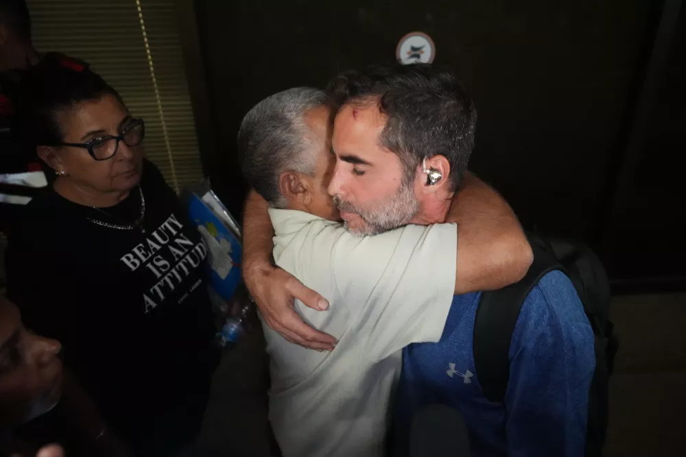 Israeli passenger Asaf Rajuan, right, who experienced an emergency landing in Saudi Arabia, during a flight on a FlyDubai plane, hugs another passenger from the same flight as they arrive at Ben Gurion International Airport, near Tel Aviv, Israel, Wednesday, Sept. 30, 2026. (AP Photo/Ariel Schalit)