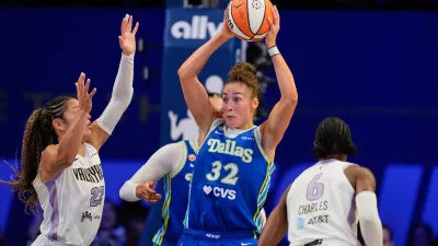 Dallas Wings' Jessica Shepard (32) looks to make a pass after collecting a rebound between Golden State Valkyries' Veronica Burton (22) and Kaila Charles (6) during the second half of a WNBA basketball first-round playoff game Wednesday Sept. 30, 2026, in Arlington, Texas. (AP Photo/Tony Gutierrez)