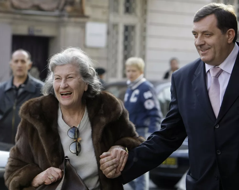 Former Bosnian Serb President Biljana Plavsic, left, reacts with Bosnian Serb Prime Minister Milorad Dodik, right, after arriving in Belgrade, Serbia, Tuesday, Oct. 27, 2009. Plavsic arrived in Belgrade Tuesday following her release from a Swedish prison after serving two-thirds of her 11-year sentence for war crimes. (AP Photo/Srdjan Ilic)
