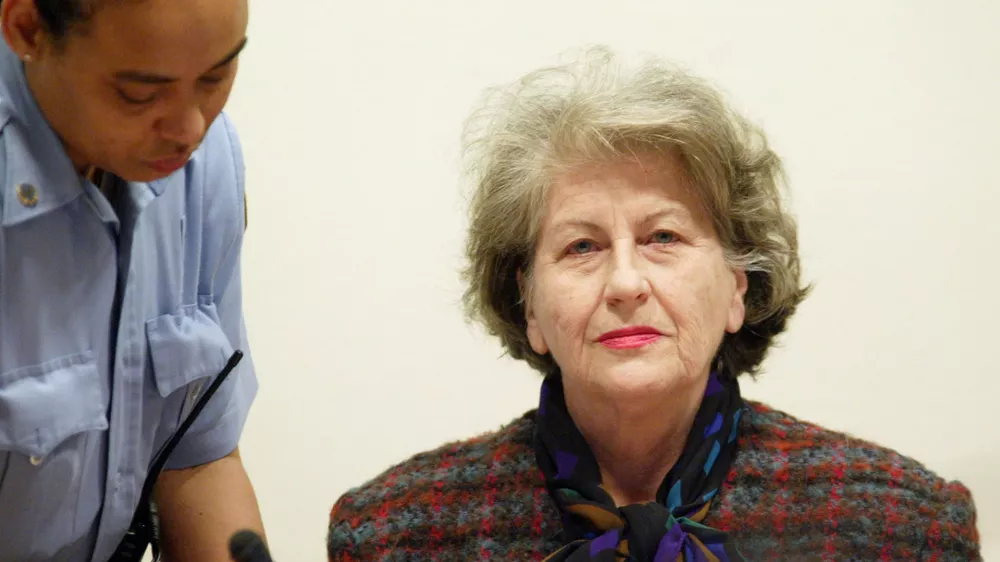 Ex-Bosnian Serb President Biljana Plavsic (R) is escorted by a United Nations security guard at the beginning of her sentencing hearing at the U.N. International Criminal Tribunal for the former Yugoslavia, in The Hague, December 16, 2002. The former biology professor had initially pleaded innocent to multiple counts of genocide, crimes against humanity and war crimes after surrendering to the U.N. court in January 2001. Plavsic, 72, changed her plea in October to guilty on one charge of persecution in what lawyers said was a move "expressing her remorse fully and unconditionally". REUTERS/Fred Ernst/Pool