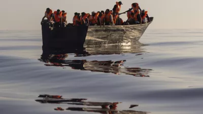 FILE - Migrants with life jackets provided by volunteers of the Ocean Viking, a migrant search and rescue ship run by NGOs SOS Mediterranee and the International Federation of Red Cross (IFCR), sail in a wooden boat as they are being rescued some 26 nautical miles&nbsp;south of the Italian Lampedusa island in the Mediterranean sea,&nbsp;on Aug. 27,&nbsp;2022. The U.N. human rights chief is appealing to governments to do more to help migrants and asylum-seekers after a "steep increase" in the numbers making risky attempts to cross the central Mediterranean to Europe. (AP Photo/Jeremias Gonzalez, File)