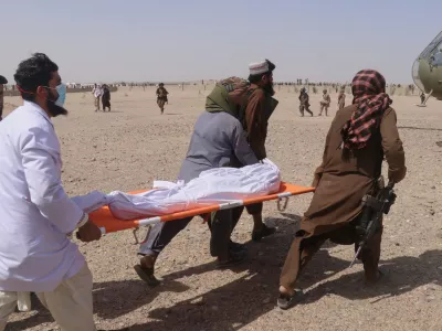 Afghan men carry a body toward a helicopter for evacuation from the site of what Afghanistan's Taliban government said was an overnight Pakistani airstrike in Helmand province, southwestern Afghanistan, Thursday, Oct. 1, 2026. (AP Photo/Abdul Khaliq)