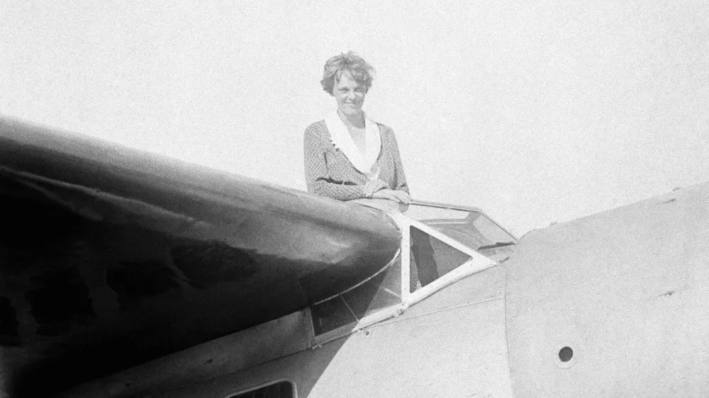 FILE - In this undated photo, Amelia Earhart, the first woman to cross the Atlantic Ocean by plane sits on top of a plane. Secretary of State Hillary Rodham Clinton is wading into one of the 20th century's most enduring mysteries: the fate of American aviator Amelia Earhart, disappeared over the South Pacific 75 years ago. Clinton is meeting March 20, 2012, with historians and scientists from The International Group for Historic Aircraft Recovery, which will launch a new search in June for the wreckage of Earhart's plane off the remote island of Nikumaroro. (AP Photo)