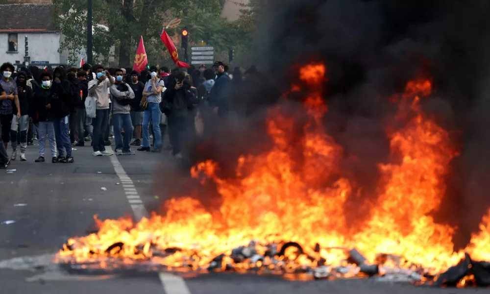 French high school and university students stand near burning garbage bins amid clashes during a protest to demand the hiring of substitute teachers, increased resources and better learning conditions, and to support the ongoing high-school student movement in the Seine-Saint-Denis department, in Saint-Denis near Paris, France, October 1, 2026. REUTERS/Abdul Saboor