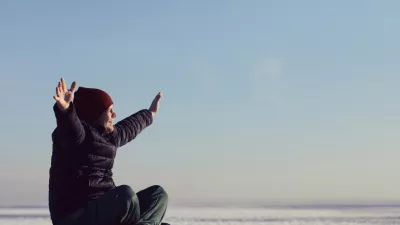 a young man sits in the winter on the ice of snow and looks at the sun. space for text