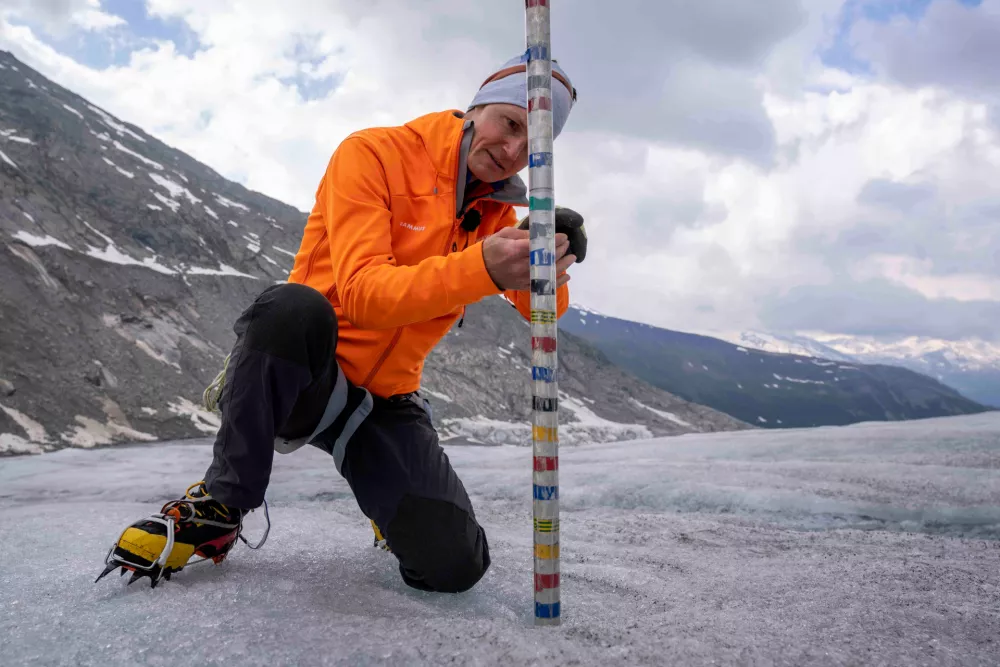 FILE - ETH (Swiss Federal Institute of Technology) glaciologist and head of the Swiss measurement network Glamos, Matthias Huss, checks the thickness of the Rhone Glacier near Goms, Switzerland, June 16, 2023. (AP Photo/Matthias Schrader, File) / Foto: Matthias Schrader