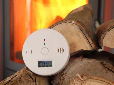 a CO detector in front of a burning fireplace