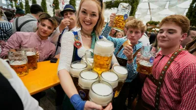 A waitress carries beer mugs after the opening of the 191st Oktoberfest beer festival in Munich, Germany, Saturday, Sept.19, 2026. (AP Photo/Matthias Schrader)