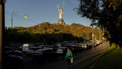 A woman walks near the Ukrainian Motherland Monument along a street that is clogged with cars headed to the left bank of the city, after Russian drone strikes on Kyiv's bridges caused disruptions, amid Russia's attack on Ukraine, in Kyiv, Ukraine October 2, 2026. REUTERS/Thomas Peter