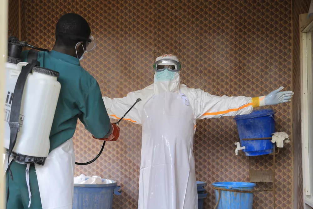 A healthcare worker in protective clothing is disinfected by a colleague inside a treatment center for Ebola patients in Beni, North Kivu province, eastern Congo, Saturday, Sept. 26, 2026. (AP Photo/Sebastien Kitsa Musayi)