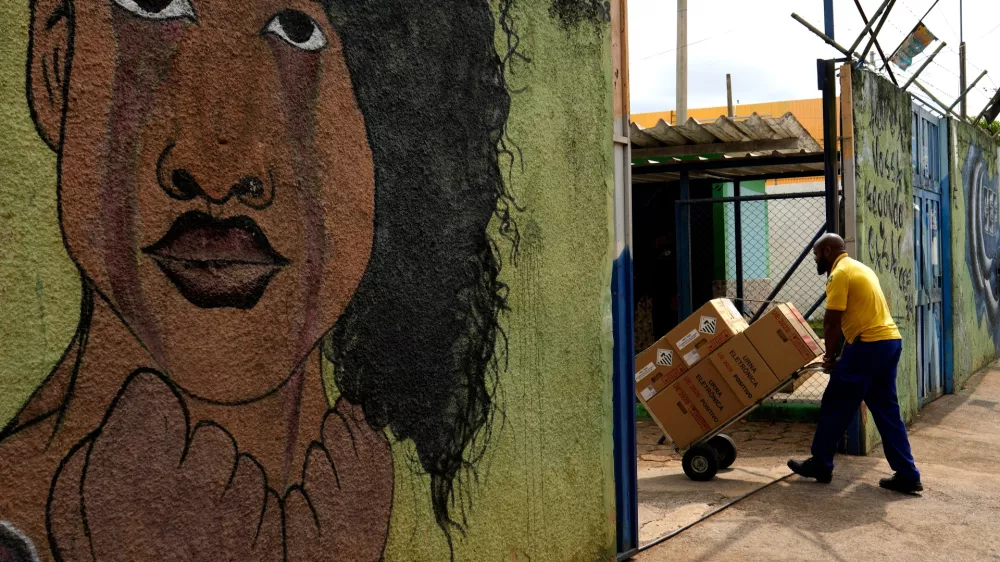 A worker transports boxes containing electronic voting machines into a public school where polling stations will be set up ahead of the general elections in Brasilia, Brazil, Friday, Oct. 2, 2026. (AP Photo/Eraldo Peres)