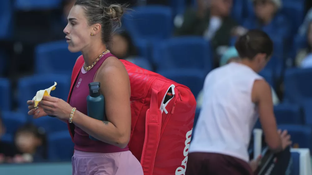 Aryna Sabalenka, of Belarus, left, leaves the court after lost in the third round of the women's singles match to Nikola Bartunkova, of the Czech Republic, at the China Open tennis tournament in Beijing, Sunday, Oct. 4, 2026. (AP Photo/Achmad Ibrahim)