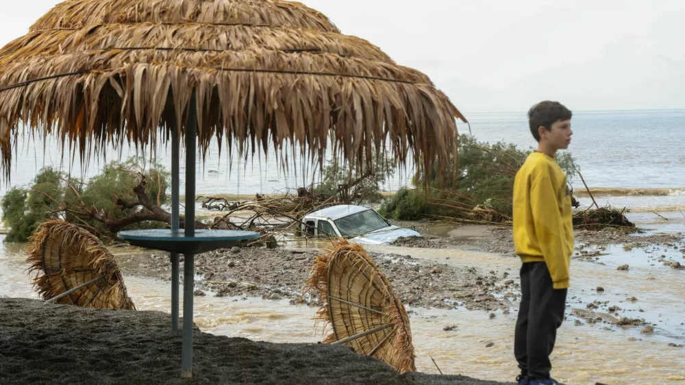A boy stands by a damaged beach bar, after heavy rain continues to affect parts of Crete, prompting authorities to maintain severe weather warnings, in Therma near Ierapetra, Crete island, Greece, October 3, 2026. REUTERS/Stefanos Rapanis   TPX IMAGES OF THE DAY