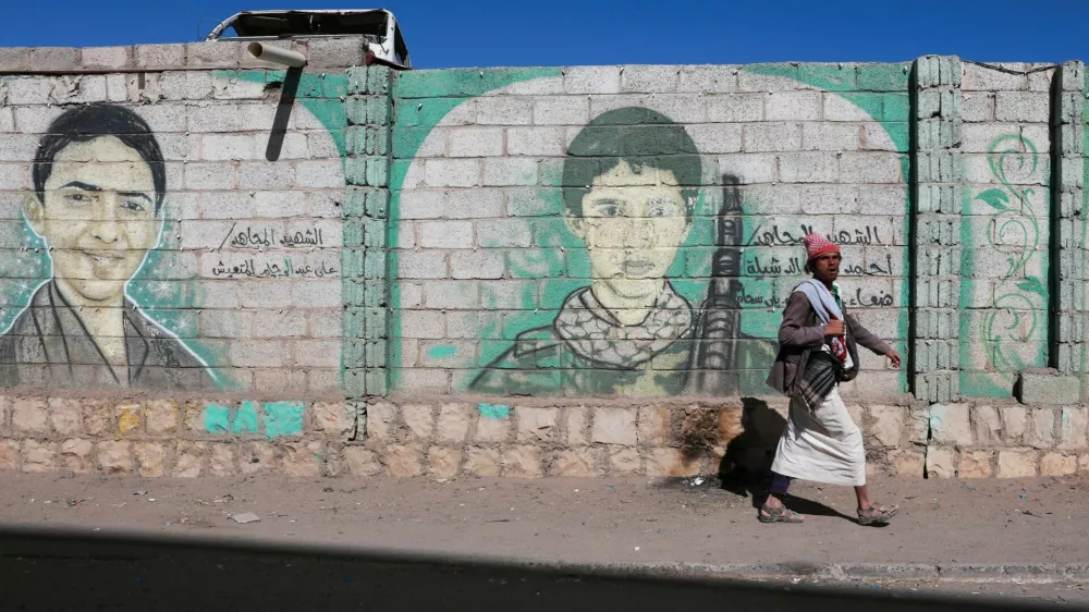 A man walks past murals of dead Houthi fighters on a wall in Sanaa, Yemen October 4, 2026. REUTERS/Stringer