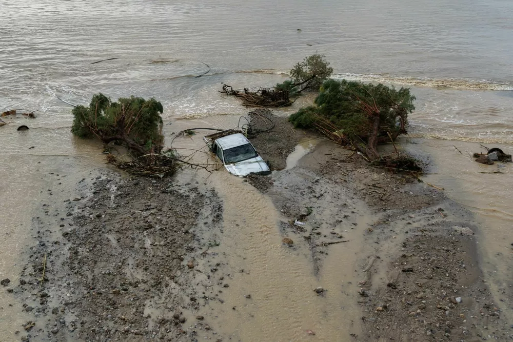 A drone view of a car and trees washed into the sea, after heavy rain continues to affect parts of Crete, prompting authorities to maintain severe weather warnings, in Therma near Ierapetra, Crete island, Greece, October 3, 2026. REUTERS/Stefanos Rapanis   TPX IMAGES OF THE DAY