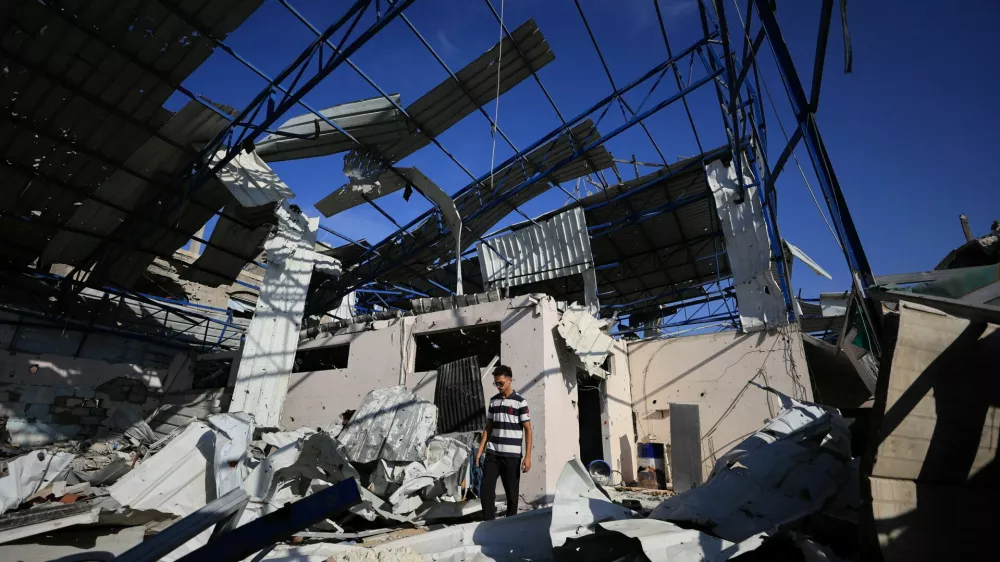 A Palestinian young man stands amid the debris of Al-Hassayna family's company warehouse, damaged during the war, in Gaza City, September 28, 2026. REUTERS/Dawoud Abu Alkas
