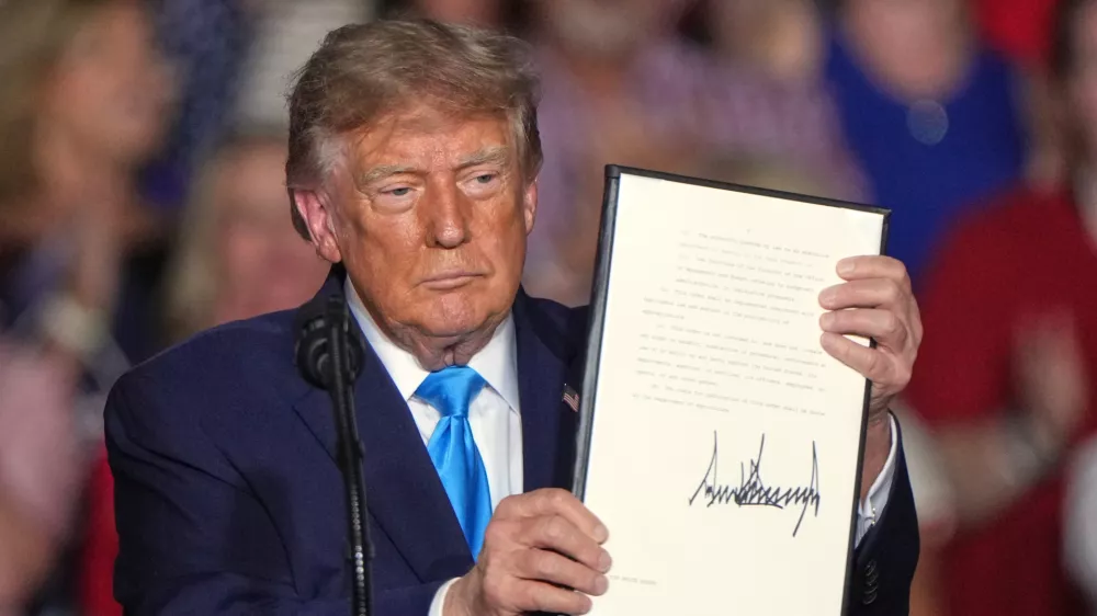 President Donald Trump holds a signed executive order at a campaign rally at the Pinnacle Bank Expo Center, Monday, Oct. 5, 2026, in Grand Island, Neb. (AP Photo/Charlie Riedel)