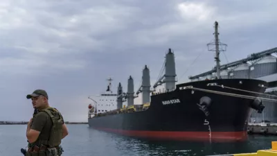 FILE - A security officer stands next to the ship Navi-Star which sits full of grain since Russia's invasion of Ukraine began five months ago as it waits to sail from the Odesa Sea Port, in Odesa, Ukraine, on July 29, 2022. Russia has repeatedly fired missiles and drones at Ukrainian ports key to sending grain to the world. Moscow has declared large swaths of the Black Sea dangerous for shipping. (AP Photo/David Goldman, File)
