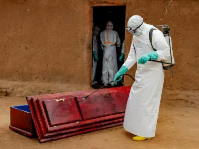 FILE PHOTO: Members of the Civil Protection, a local community-based team that works to help mitigate the spread of the Ebola virus and ensure burials happen safely and quickly, wearing personal protective equipment (PPE), disinfect a wooden coffin before loading the body of an unidentified man, who according to his family, died of Ebola, as they retrieve it from his house, as aid agencies intensify efforts to contain a new Ebola outbreak involving the Bundibugyo strain, in Bunia, Ituri province, Democratic Republic of Congo, July 10, 2026. REUTERS/Gradel Muyisa Mumbere/File Photo