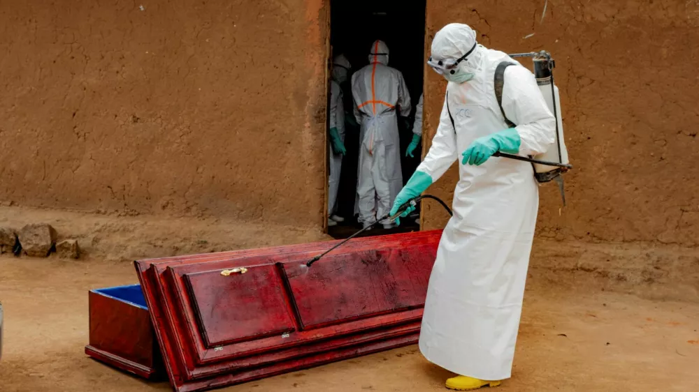 FILE PHOTO: Members of the Civil Protection, a local community-based team that works to help mitigate the spread of the Ebola virus and ensure burials happen safely and quickly, wearing personal protective equipment (PPE), disinfect a wooden coffin before loading the body of an unidentified man, who according to his family, died of Ebola, as they retrieve it from his house, as aid agencies intensify efforts to contain a new Ebola outbreak involving the Bundibugyo strain, in Bunia, Ituri province, Democratic Republic of Congo, July 10, 2026. REUTERS/Gradel Muyisa Mumbere/File Photo