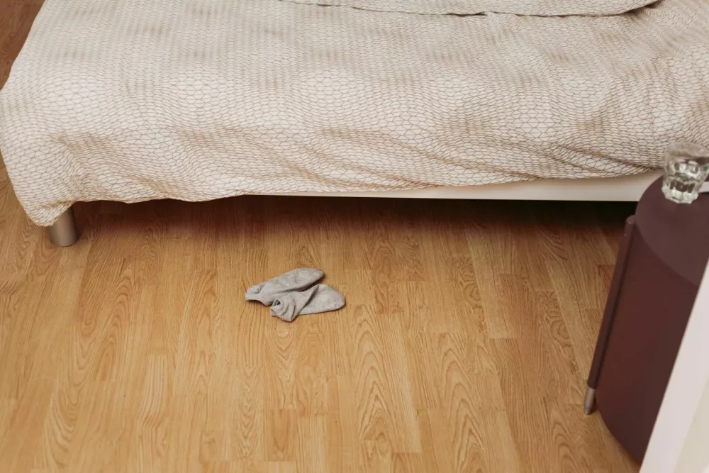 Pair of used socks on bedroom floor / Foto: Robertpetrovic