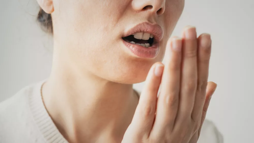Woman is checking smell of breath / Foto: Seb_ra